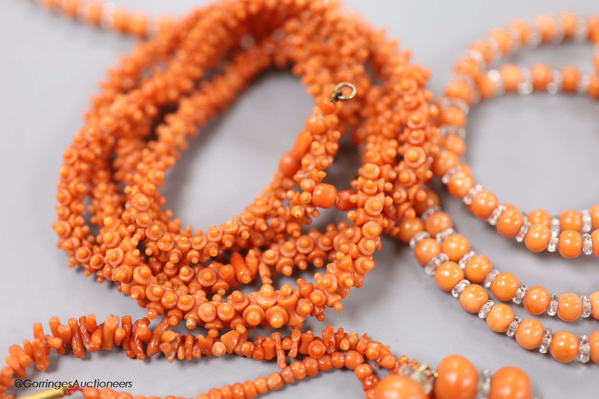 Four assorted coral bead necklaces, largest 148cm and a coral bead bracelet.